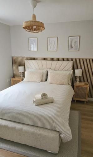 a bedroom with a white bed with a towel on it at Welcome Home in Royston