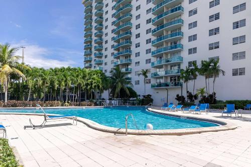 a swimming pool in front of a large building at Zen Vacation Rentals Modern Penthouse Across Ocean in Miami Beach