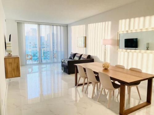 a living room with a table and chairs and a couch at Zen Vacation Rentals Modern Penthouse Across Ocean in Miami Beach
