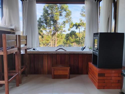 a large bathroom with a tub and a television at Pousada Anabela in Campo Alegre