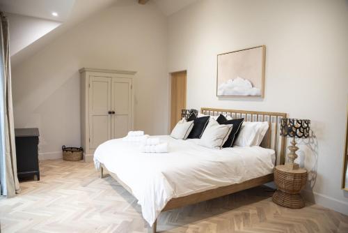 a bedroom with a large bed with white sheets and pillows at Highland House in Lochearnhead