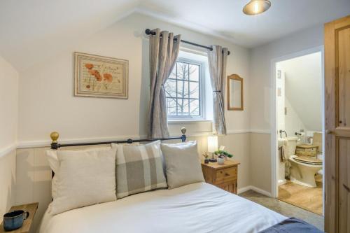 a bedroom with a bed with a window and a bathroom at 2 Bed in Wickhampton oc-t34449 in Wickhampton