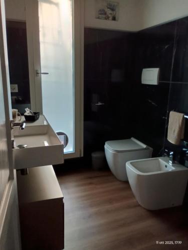 a bathroom with a white toilet and a sink at Fienile Paradiso Home Tuscany in Campi Bisenzio