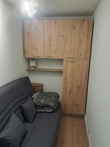 a living room with a couch and a wooden cabinet at 265 rue du clos capperony in Les Rousses