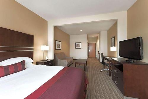 a hotel room with a bed and a flat screen tv at Hotel Willowbrook in Houston