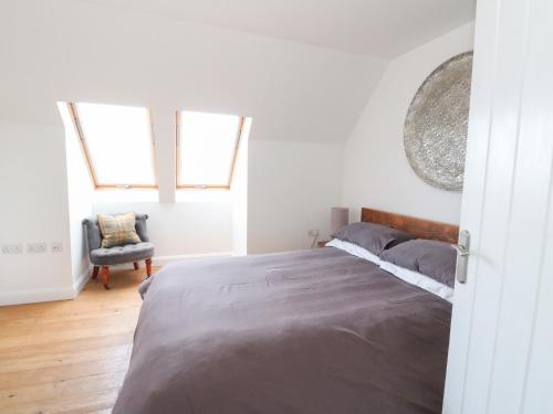 a bedroom with a large bed and a chair at Sealladh in Appin