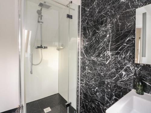 a bathroom with a shower with a black marble wall at Sealladh in Appin