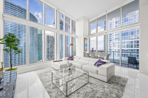 a living room with a white couch and large windows at Icon Brickell Residences in Miami