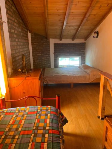 a bedroom with a bed and a wooden floor at Torres del Piltri in El Bolsón