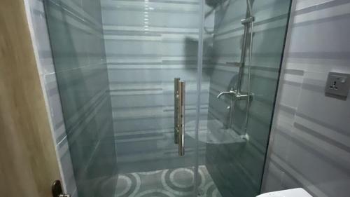 eine Dusche mit Glastür im Badezimmer in der Unterkunft Clear Gates Hotel in Ekete