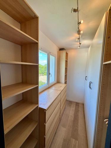 a small room with wooden shelves and a window at Villa avec piscine Proche de ROYAN in Sémussac