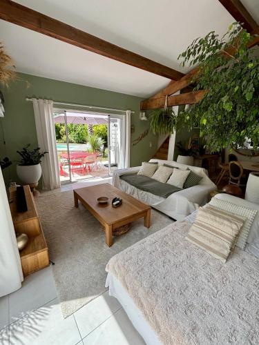 a living room with a bed and a table at Villa avec piscine Proche de ROYAN in Sémussac