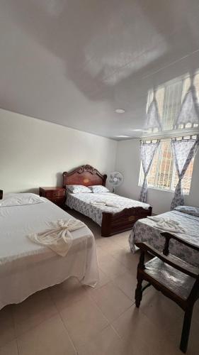 a bedroom with two beds and a window at Casa Turística Samanta in Buga