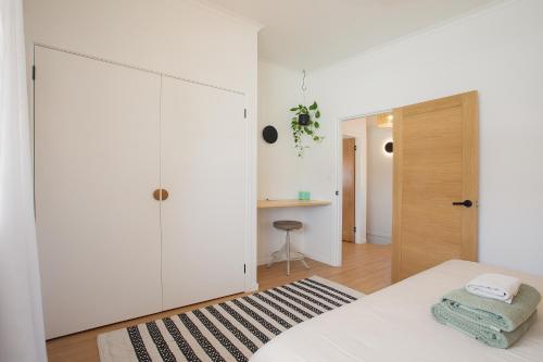 a bedroom with white cabinets and a bed with a black and white rug at Garden Oasis-2br -1 min from the beach & pet friendly! in Suffolk Park
