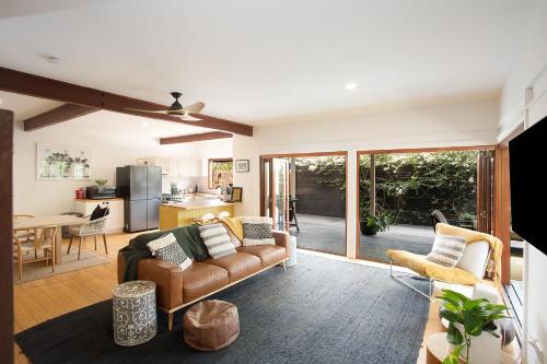 a living room with a couch and a kitchen at Garden Oasis-2br -1 min from the beach & pet friendly! in Suffolk Park
