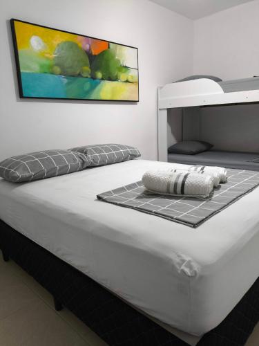 a white bed with a black and white mattress at Casinha Guest House in Saquarema