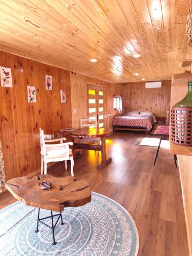 a living room with wooden walls and wooden floors at Cabaña monoambiente in Quellón