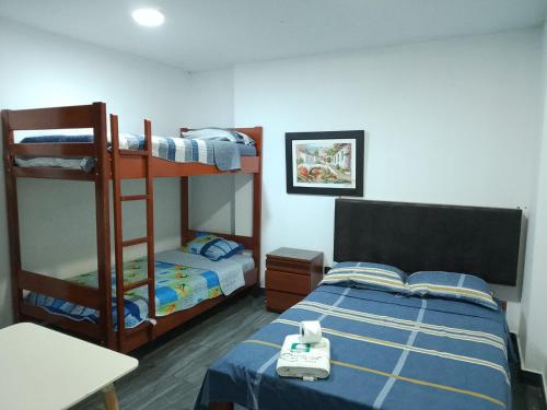a bedroom with two bunk beds and a table at Hotel Ruah in Tumbes