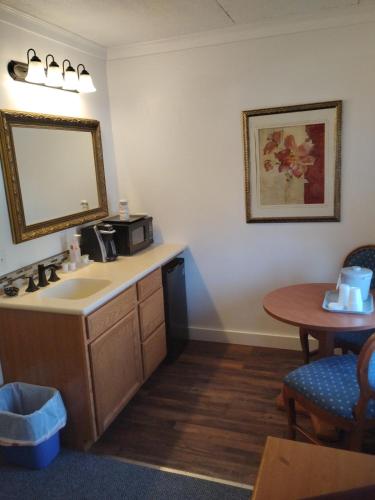 a bathroom with a sink and a mirror and a table at acadia sunrise motel in Trenton