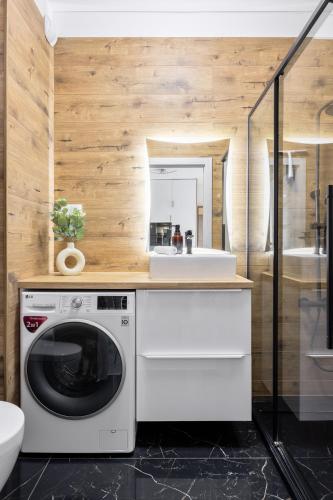a washing machine in a bathroom with a sink at Hygge Amber Aparts - 9th floor in Gdańsk Letnica