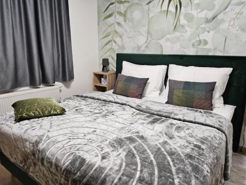 a bedroom with a bed with a green comforter and pillows at Kuca za odmor PETAR u blizini Parka prirode PAPUK in Lisičine