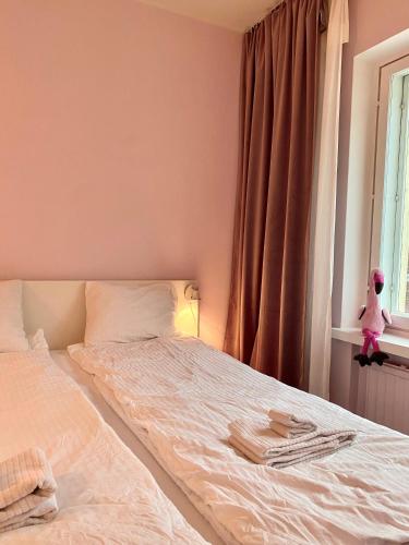 a bedroom with a bed with white sheets and a window at Studio Flamingo in Helsinki
