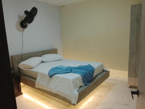 a bedroom with a bed with blue sheets and pillows at Hotel y parqueadero La Colonia Inn in Socorro