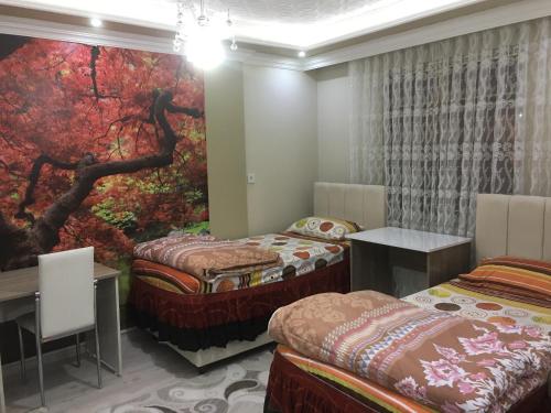 a room with two beds and a painting on the wall at Bandirma Saglik Apart in Bandırma