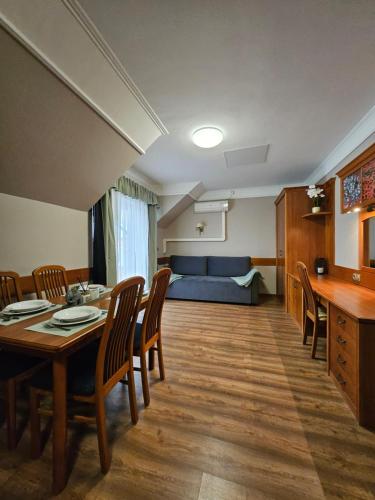 a living room with a table and chairs and a couch at Keller Apartman in Cserszegtomaj