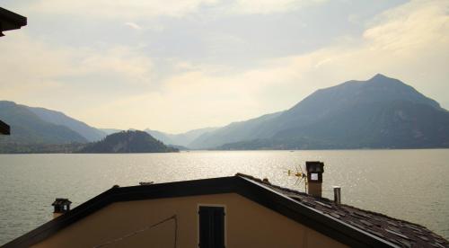 a view of a large body of water with mountains at Milk River - beach front, railway station, lake view in Varenna