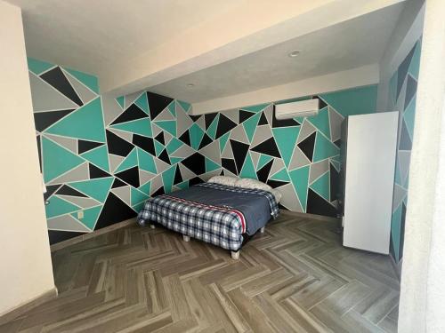 a bedroom with a bed and a geometric wall at Exclusive paradise surrounded by nature in Alpuyeca