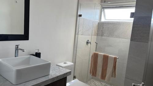 a white bathroom with a sink and a shower at Sunset view luxury in Cedro