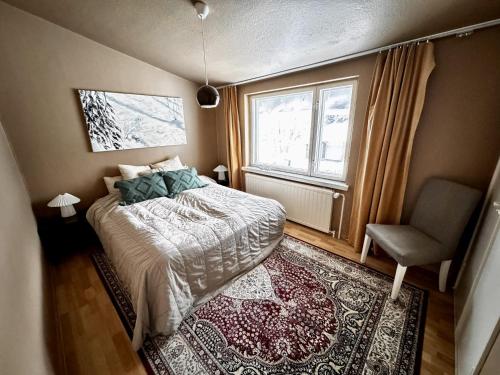 a bedroom with a bed and a chair and a window at Guesthouse Sahanpera in Rovaniemi