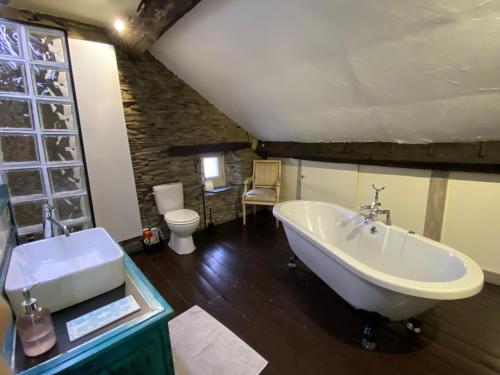 ein Badezimmer mit einer großen Badewanne und einem Waschbecken in der Unterkunft L'Ardoise in Bertrix