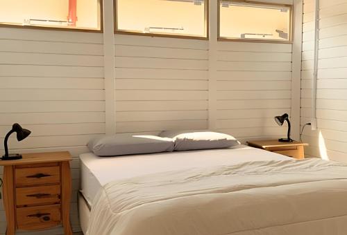 a bedroom with a bed and two lamps on tables at Villa Di Mare 2 - Pool, fire pit, and barbecue grill in São Francisco do Sul
