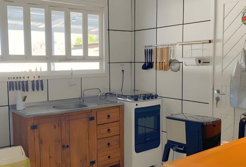 a kitchen with a sink and a stove at Villa Di Mare 2 - Pool, fire pit, and barbecue grill in São Francisco do Sul