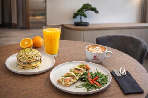 a table with two plates of food and a cup of coffee at Mountain Pine Luxury Suites in Florina