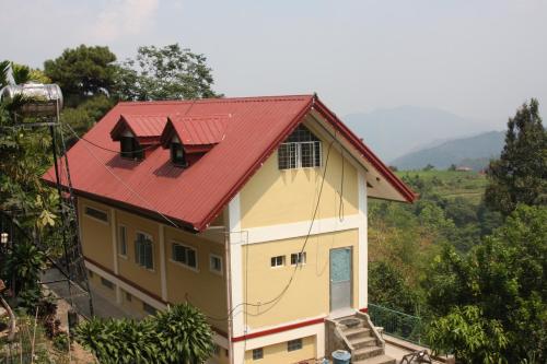 ein kleines Haus mit rotem Dach in der Unterkunft Mayoyao View Inn in Banaue