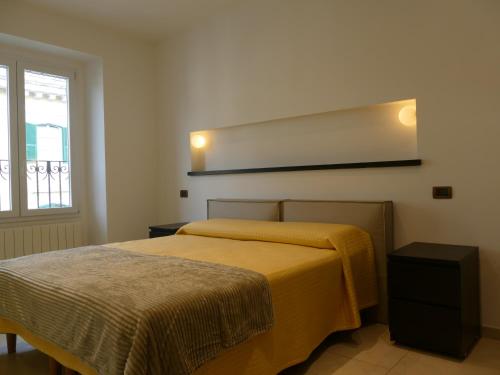 a bedroom with two beds and a mirror on the wall at Andrea Appartamenti in Savona