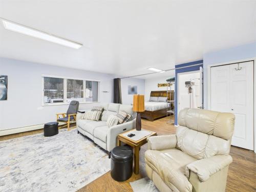 a living room with two couches and a table at Large Juneau Loft w Full Kitchen, WD & Workspace in Juneau
