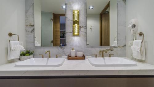 a white bathroom with a large sink and a mirror at Luxury Oceanfront Condo with Stunning Views in Puerto Peñasco