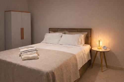 a bedroom with a bed with towels on it at Lar Urbano in Manhuaçu