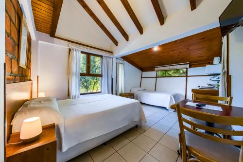 a bedroom with a white bed and a desk and a window at Mirando al Sur in San Carlos de Bariloche