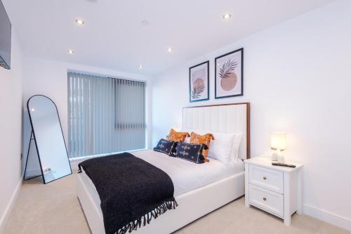 a white bedroom with a bed and a window at Leeds Lux Apartment - 2 Bed & Pool Table, Secure Parking in Leeds