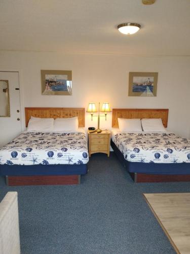 a bedroom with two beds and a night stand with two lamps at acadia sunrise motel in Trenton