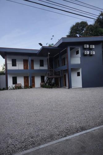 a blue and white building with a gravel driveway at Las Morenas in Nosara