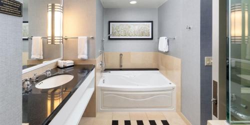 Un baño con bañera blanca y lavabo. en Caesars Windsor, A Caesars Destination, en Windsor