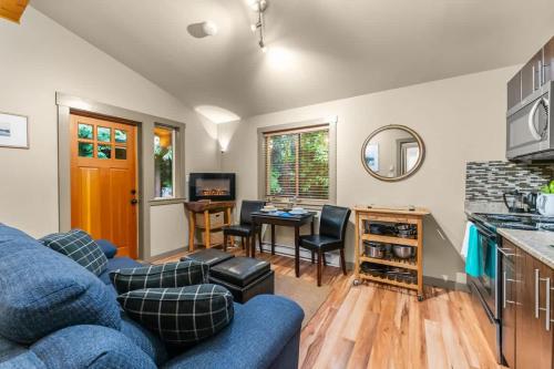 a living room with a blue couch and a table at JDF Waystation Cabin - Garden View - Pet Friendly in Port Renfrew