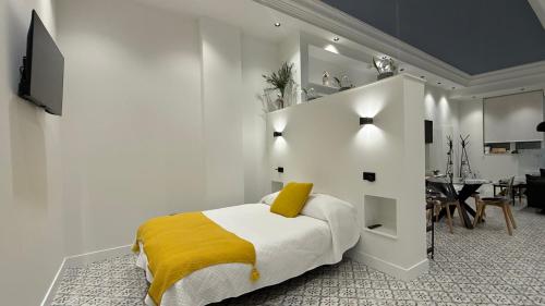 a bedroom with a bed with a yellow blanket at Alojamiento Lope d vega in Alba de Tormes