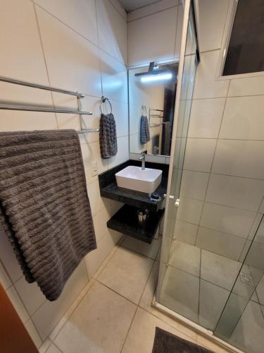 a bathroom with a sink and a shower at Ap Clube Piçarras in Piçarras
